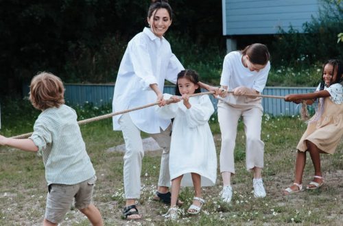 Family playing tug of war in backyard, showcasing teamwork and joy.